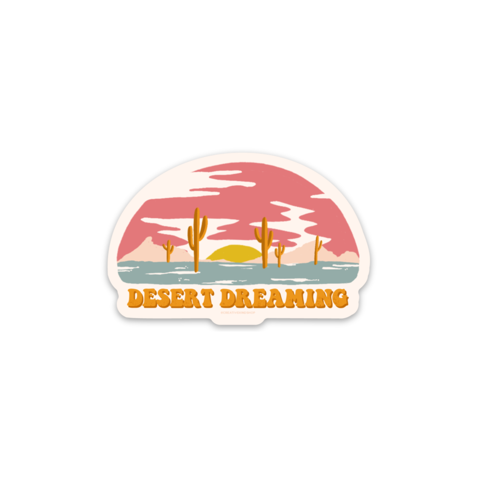 Tan die cut sticker with desert sunset above the words "desert dreaming"