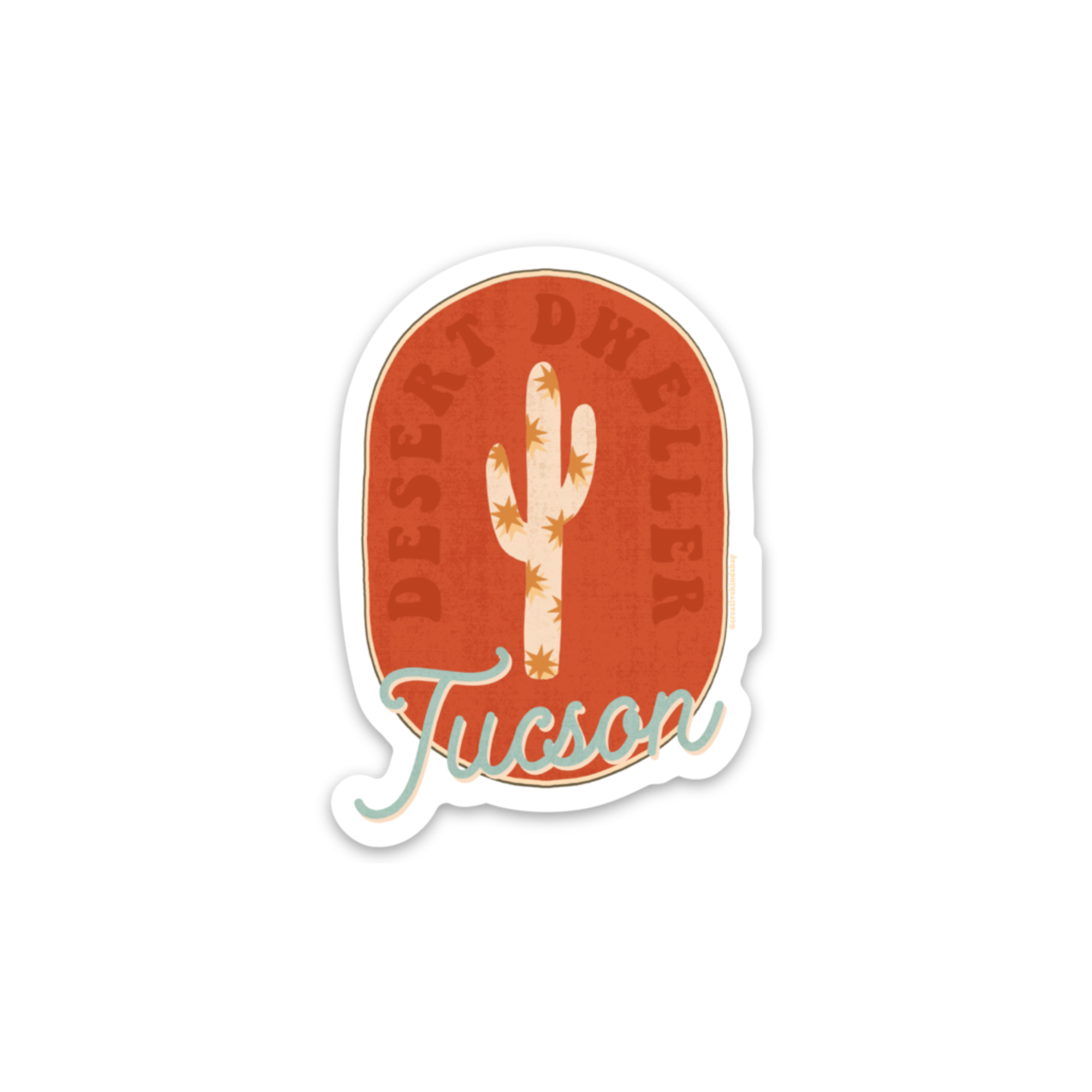 Oval sticker with red background and tan cactus with the words "desert dweller tucson"