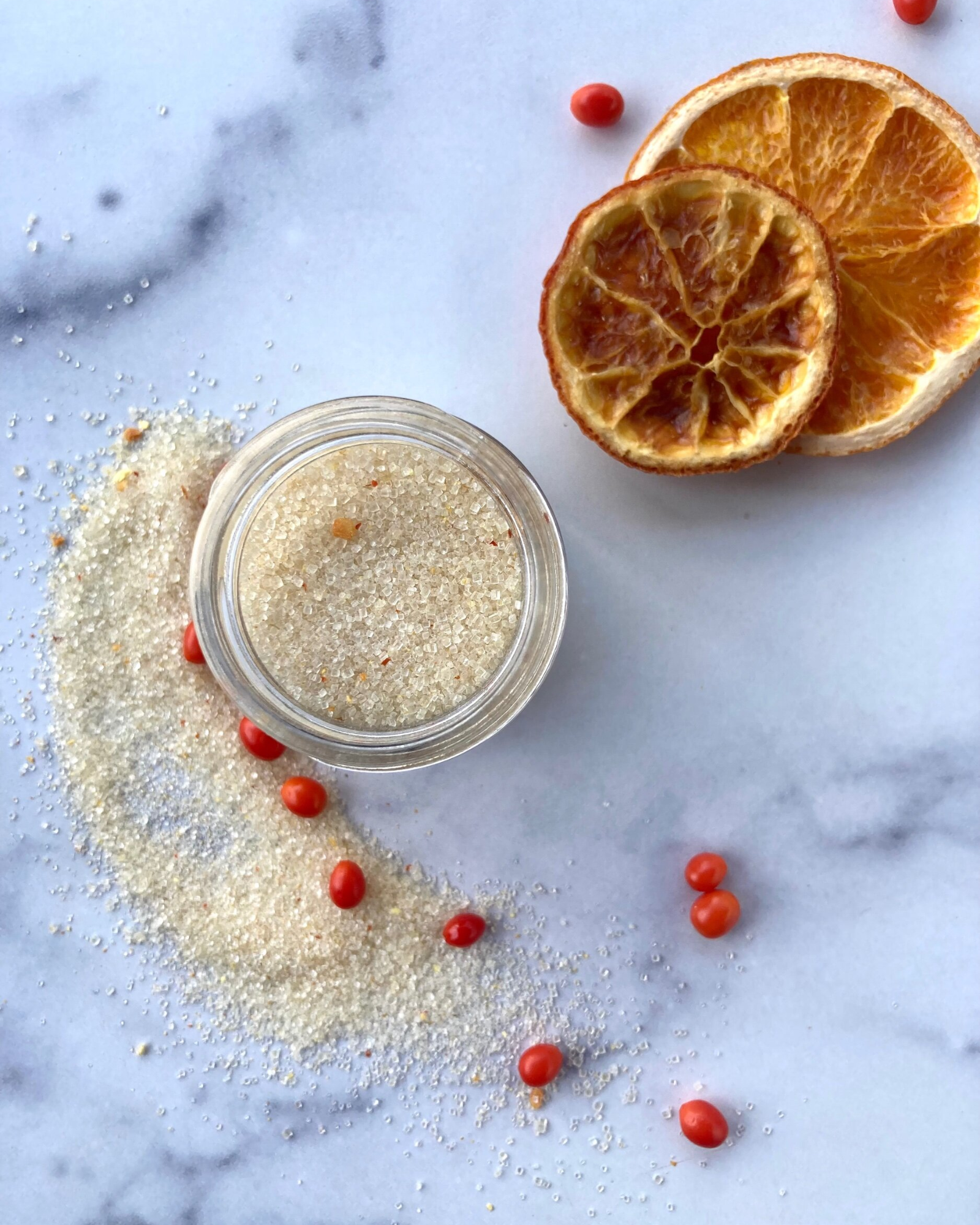 Open jar of sonoran sweet heat sugar next two two dried oranges and berries