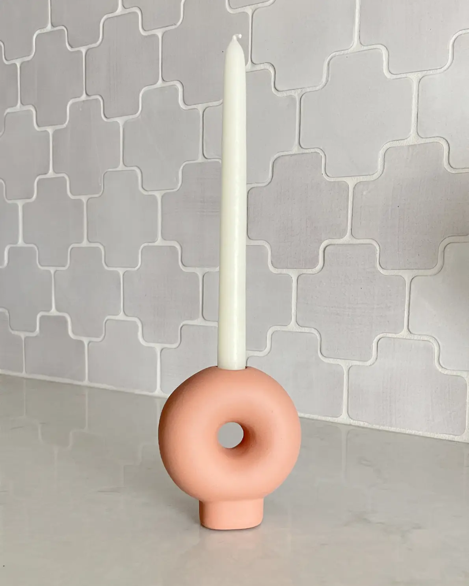 Bagel candle holder with single white taper candle