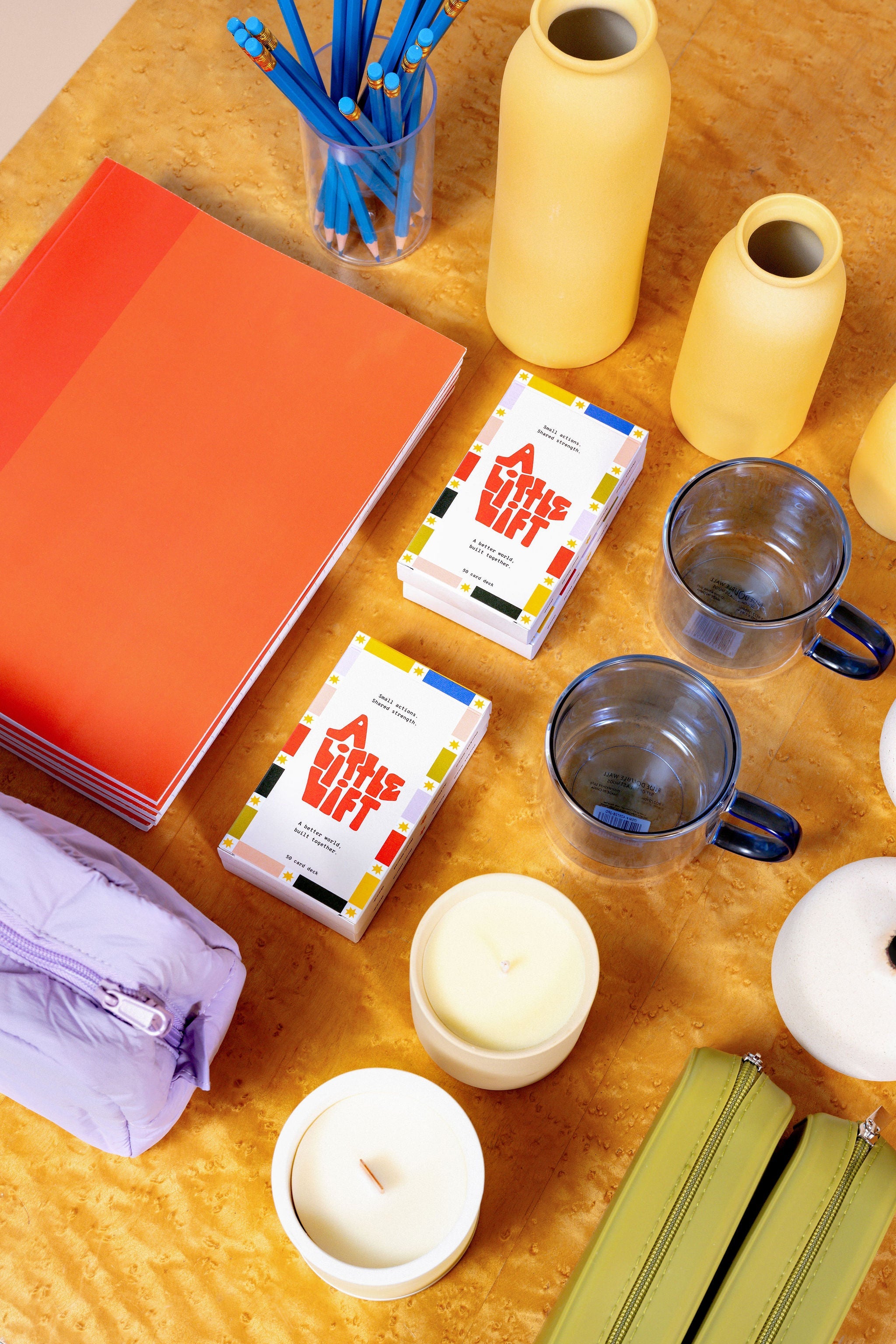 Colorful card deck A Little Lift in a grid of gift items including an orange journal, yellow vases, candles, blue mugs, pencils