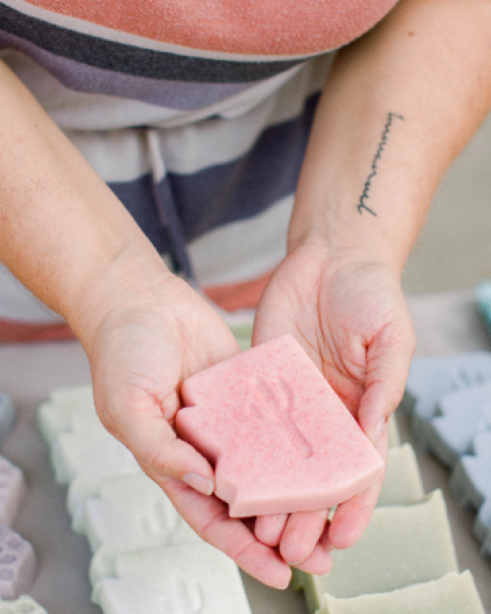 Woman holding pink arizona shaped soap in outstretched hands
