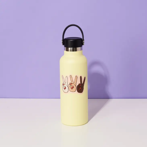 Yellow water bottle with purple background. Water bottle has peace hands vinyl sticker on it.