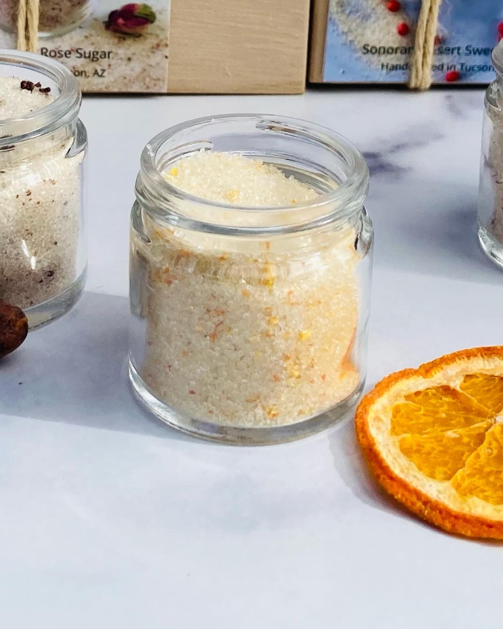 Open jar of sonoran sweet heat sugar next to a dried orange